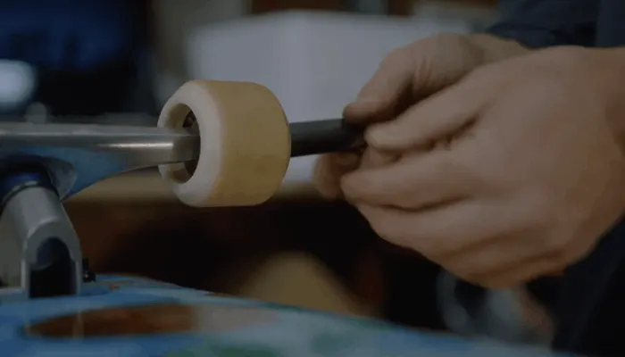 A hand sliding a wheel back onto a truck axle